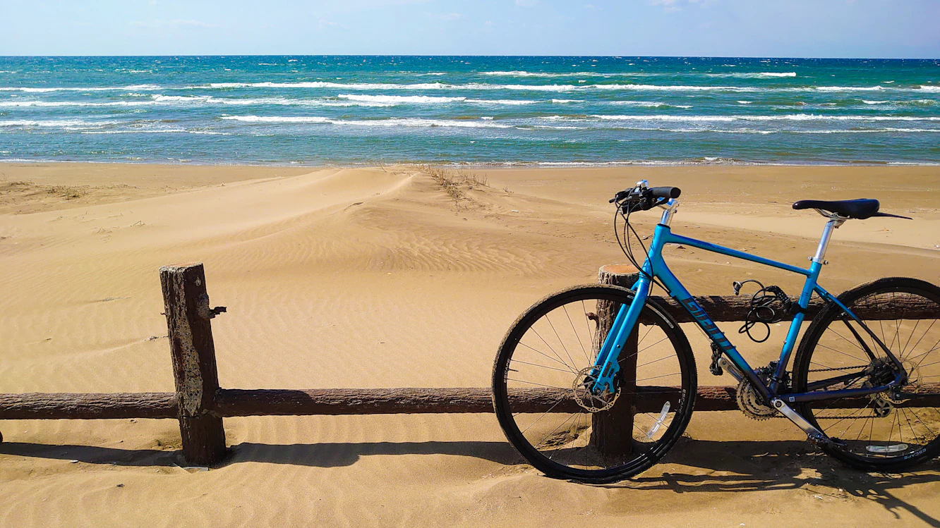 Vélo appuyé contre une barrière sur une plage